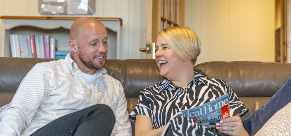 Couple relaxing on sofa in holiday lodge