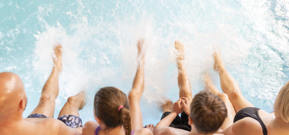 Family splashing their feet in the swimming pool